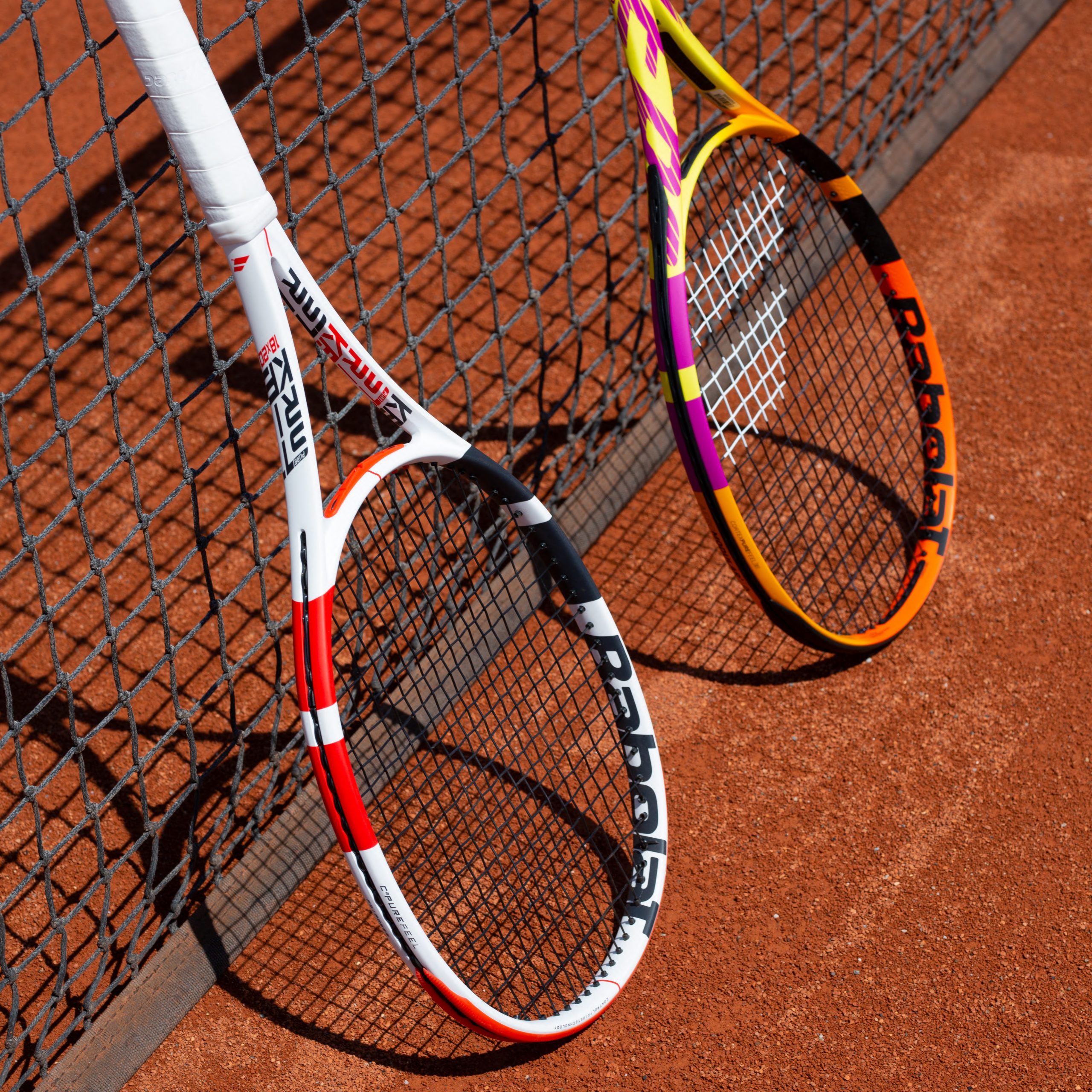 Zwei Tennisschläger am Netz auf dem Sandplatz